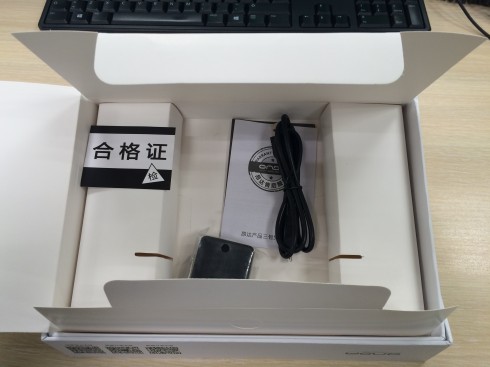 Un poco de cartoncillo del malo, cosas en chino, cargador y cable USB.